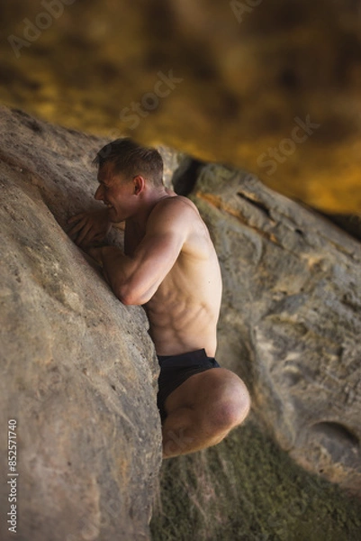 Fototapeta man climbing on rock outood bouldering
