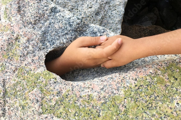 Fototapeta Hand request help from big stone hole.