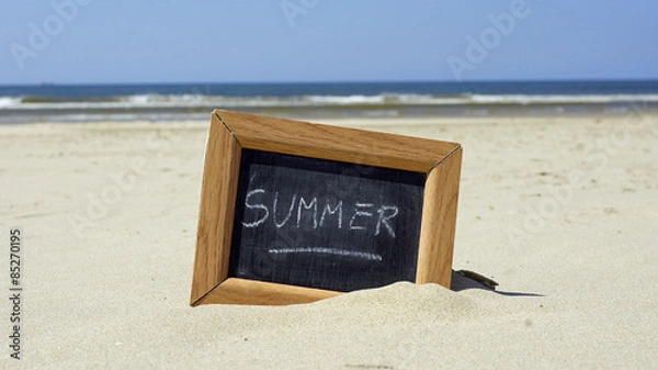 Fototapeta Summer written on a chalkboard at the beach