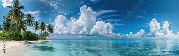 Fototapeta This image shows a tropical beach scene in the Maldives, featuring white sand, clear turquoise water, swaying palm trees, and a bright blue sky with fluffy white clouds. The tranquil scene evokes a se
