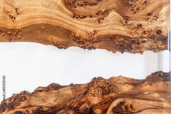 Fototapeta Live edge elm burl slab table top with central epoxy resin river on white background, combining natural wood with a synthetic material close view
