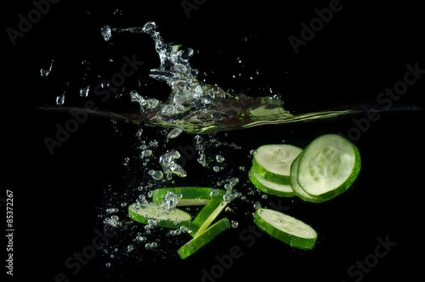 Obraz Sliced cucumber splashing water