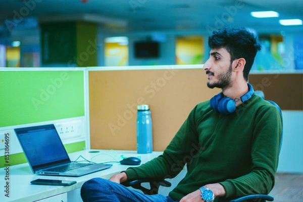 Fototapeta Portrait of young man working on laptop computer at modern startup office.