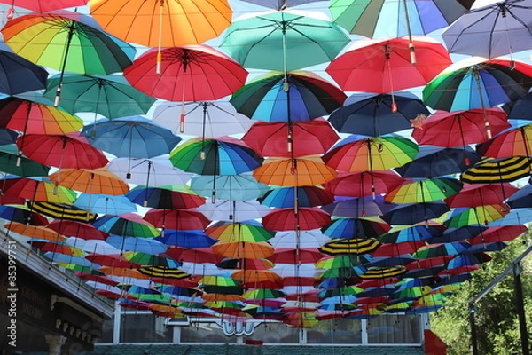 Fototapeta Under a rainbow of umbrellas.
Soaring in the sky multi-colored umbrellas.