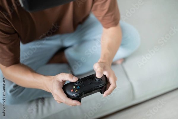 Obraz Young Asian man gamer controller video console playing holding hobby playful Online Video Game enjoyment eSport Cyber Games Internet.