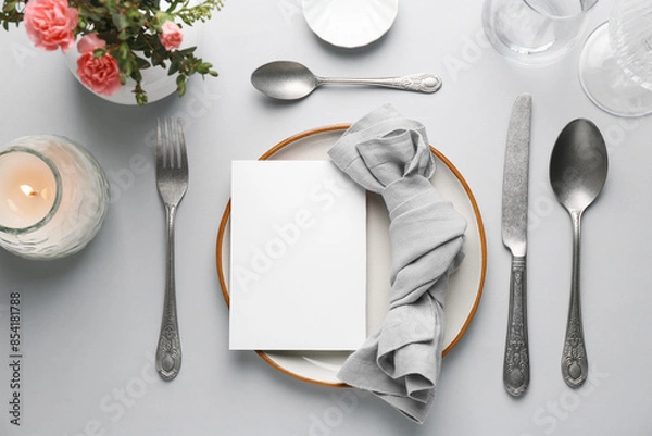 Fototapeta Empty menu, tableware, candle and floral decor on light grey table, flat lay. Mockup for design