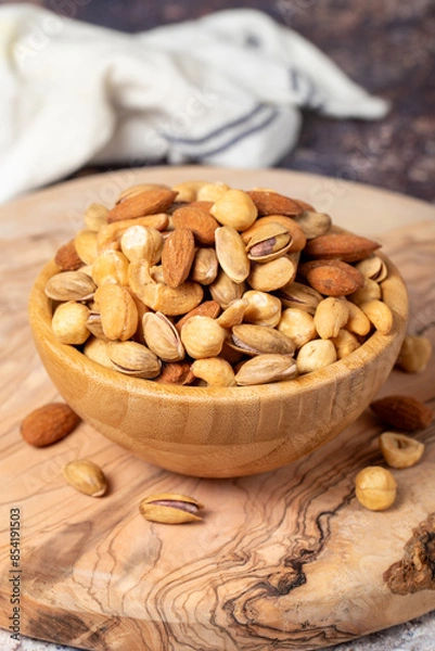 Fototapeta Mixed nuts on wooden background. Nuts in a bowl. Close up
