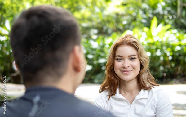 Fototapeta beautiful woman in sportswear sitting talking in a park while looking at the camera