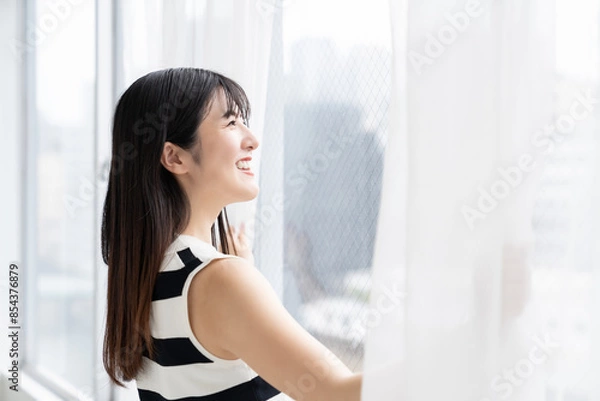 Fototapeta カーテンを開ける女性