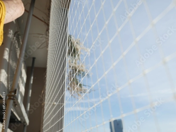 Fototapeta Cleaning dried hay of bird nest at the balcony of the condominium or apartment. Plastic net prevent and protect bird invader.