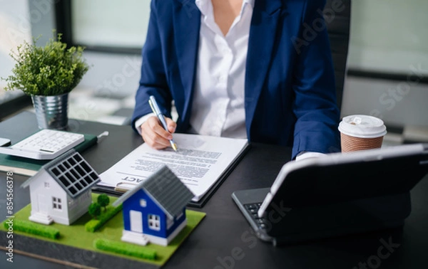 Fototapeta balancing the property sector The real estate agent is explaining the house style to see the house design and the purchase agreement. model house and comdo