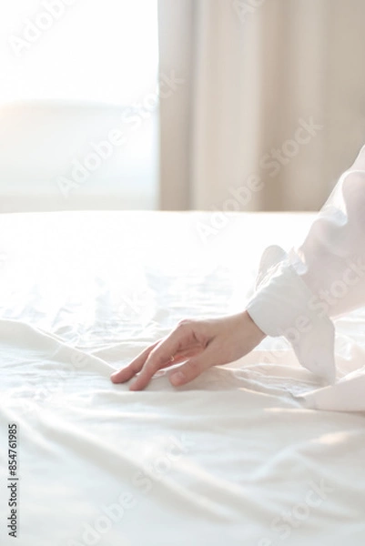 Fototapeta Hand on a soft duvet. Woman touching bed sheets, closeup. Young woman intimacy on bed. Soft, gentle, tender cozy morning concept
