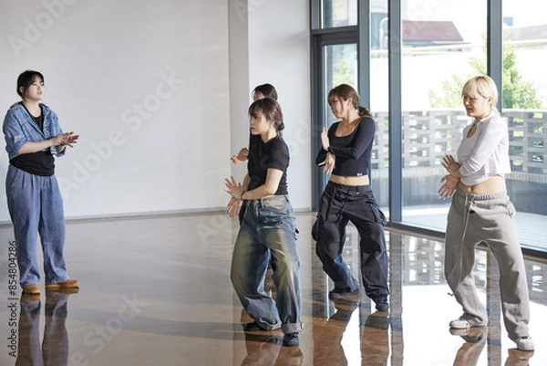 Obraz 같은 동작을 하며 함께 춤동작을 연습하는 여성 댄서들