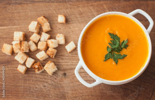 Obraz carrot soup with crackers on the wood table