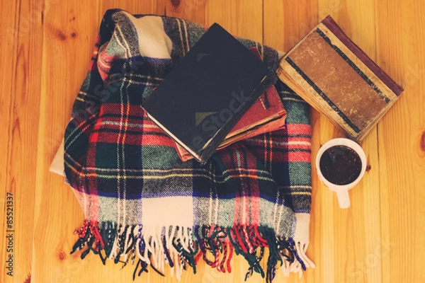 Obraz Woolen plaid, cup of tea, old books on wooden background. Top view. Toned