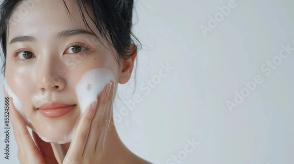 Obraz Asian model does facial cleansing young girl with foam on her face