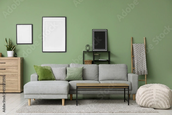 Fototapeta Interior of stylish living room with grey sofa, table and frames