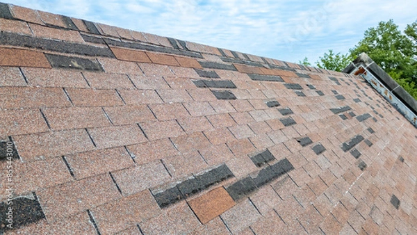 Fototapeta Roof with missing shingles from storm damage and old age
