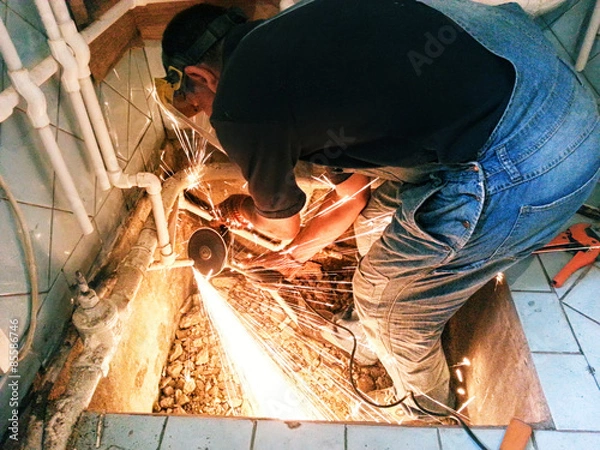 Fototapeta Plumber with angle grinder