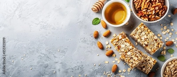 Fototapeta Vegetarian sweets. Granola bars made of sesame seeds, peanuts, cashew nuts, sunflowers seeds, oil and honey. Copy space image. Place for adding text or design