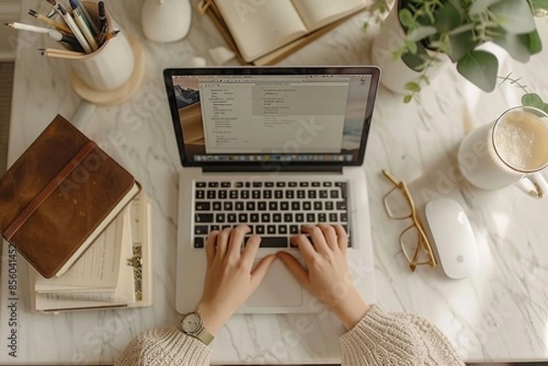 Fototapeta Freelancer Working on Laptop in Cozy Home Office, Coffee and Notebook on Desk, Overhead View. Hands with laptop Top view. Aesthetic lifestyle photo
