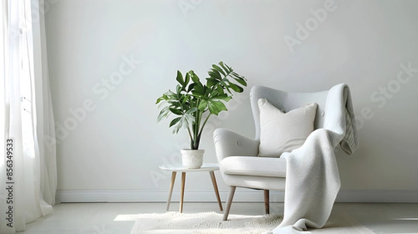 Fototapeta Modern minimal home interior design with gray armchair, white pillow, blanket, and table with green potted plant on a light wall background. Bright and elegant with copy space.