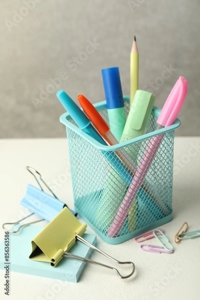 Fototapeta Holder and other different stationery on white table