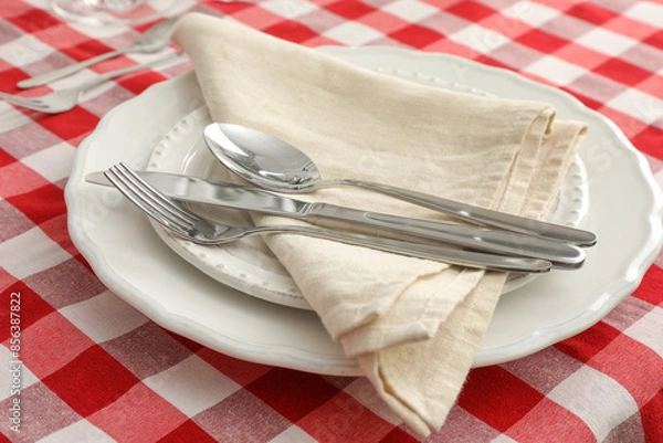 Fototapeta Stylish setting with cutlery, plates and napkin on table, closeup