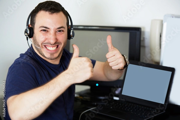 Obraz Happy call centre worker giving a thumbs up