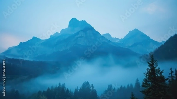 Fototapeta The mountains are covered in fog and the sky is a deep blue