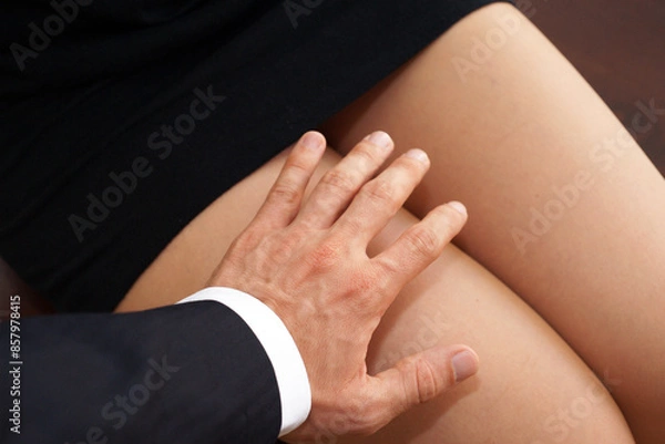 Fototapeta An example of inappropriate workplace behavior a man touching a womans thigh without permission