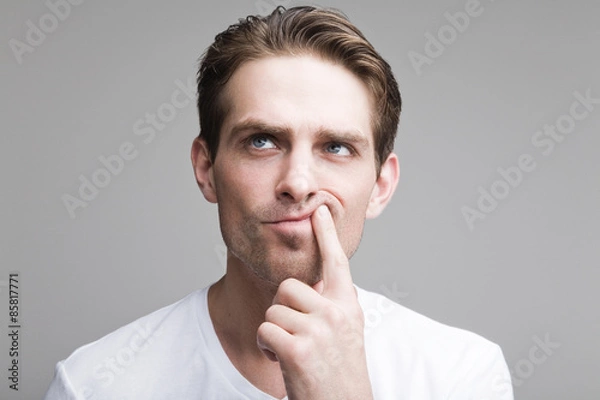 Fototapeta Thoughtful guy in a white T-shirt