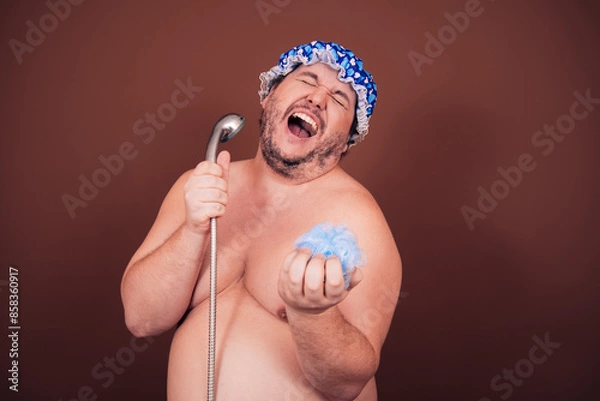 Obraz A funny fat man sings and washes in the shower. Brown background.