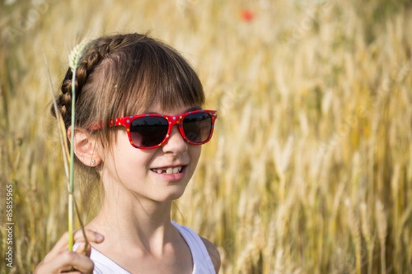Fototapeta Girl in sunglasses in the field of spike-lets