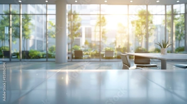 Fototapeta A modern office interior with a blurred background, white desk and glass wall, blurred focus on an open space or conference room table