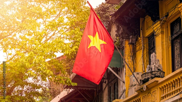 Fototapeta A red national flag of Vietnam stands above the streets of Hanoi. Symbol country