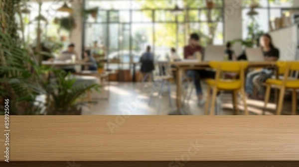 Obraz Empty wooden table in cafe background. Rustic wooden table with blurred background of people working in a modern cafe, perfect for product placement or design overlay.