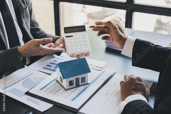 Obraz House model with agent and customer discussing calculate for price contract to buy, get insurance or loan real estate or property.