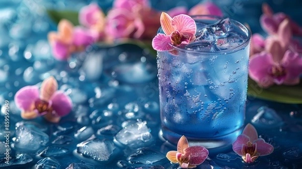 Obraz A refreshing blue drink filled with ice cubes, adorned with pink orchids, scattered on a watery surface with ice, offering a visual treat of coolness and beauty.