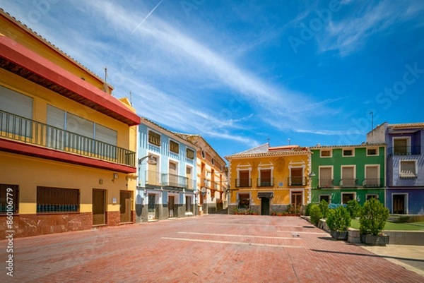 Fototapeta View of the Plaza Mayor in Pliego, Region of Murcia, Spain, with its typical colorful building facades and midday light