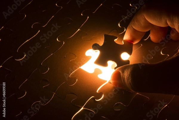 Obraz Missing jigsaw puzzle piece with light glow, business concept for completing the final puzzle piece
