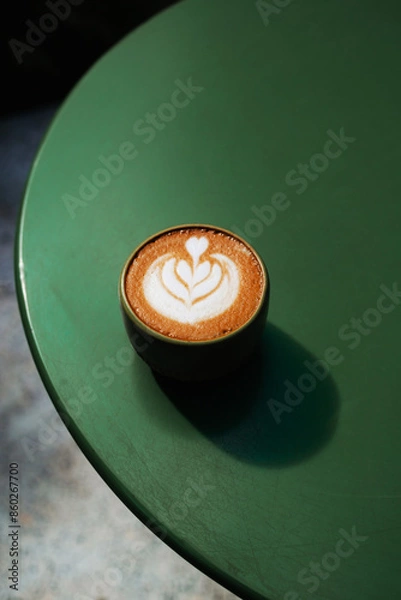 Fototapeta Cappuccino on a round table in sunlight and palm leaf shadow