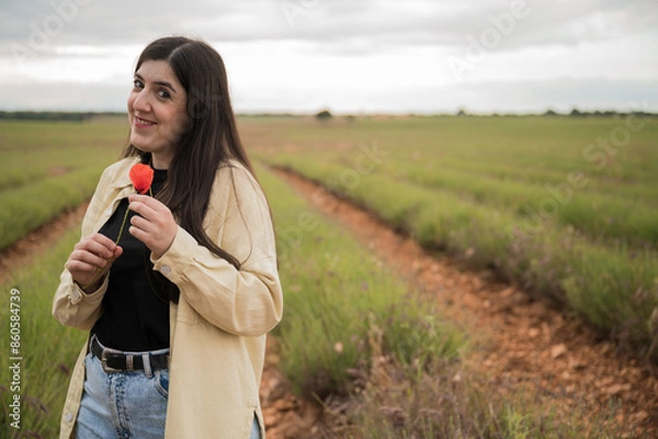 Fototapeta Friendly girl with red poppy in a wonderful lavender field