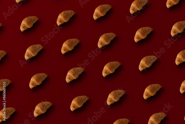 Fototapeta Pattern of baked croissants with a red background. Delicious pastries