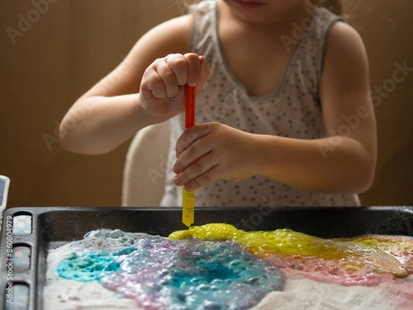 Fototapeta a child makes experiments with chemicals. experiments with soda and citric acid