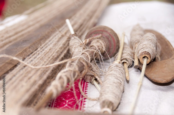 Fototapeta Wooden spindles with hemp threads