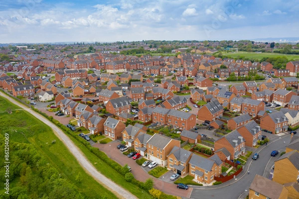 Fototapeta Aerial photo of a typical British housing estate in the village of Middleton in Leeds West Yorkshire in the UK, showing a top down drone view of suburban streets, roads and rows of houses.