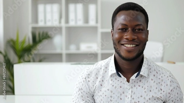 Fototapeta Professional black man, standing in front of a clean white desk, professional demeanor, over-the-shoulder portrait.