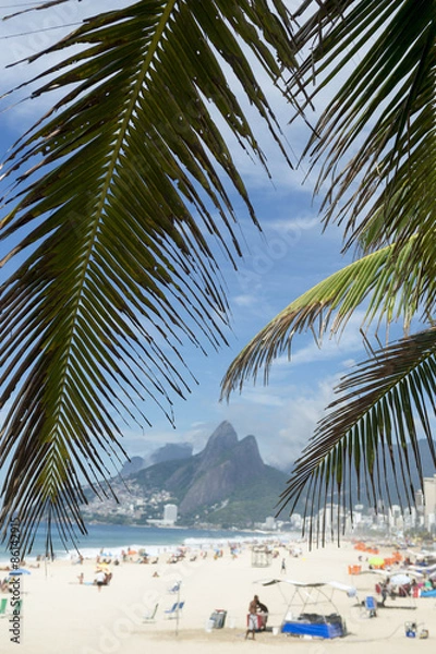 Fototapeta Palm fronds frame a scenic view of Ipanema Beach Rio de Janeiro Brazil from Arpoador 