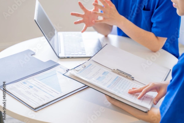 Obraz 打合せをする男女の介護士の手元